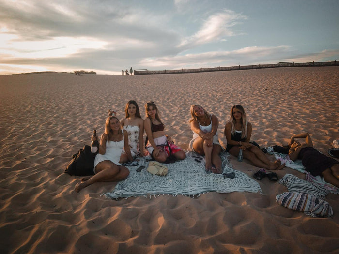 A group of friends on the beach at sunset with drinks, shot on the Love Goggles digicam